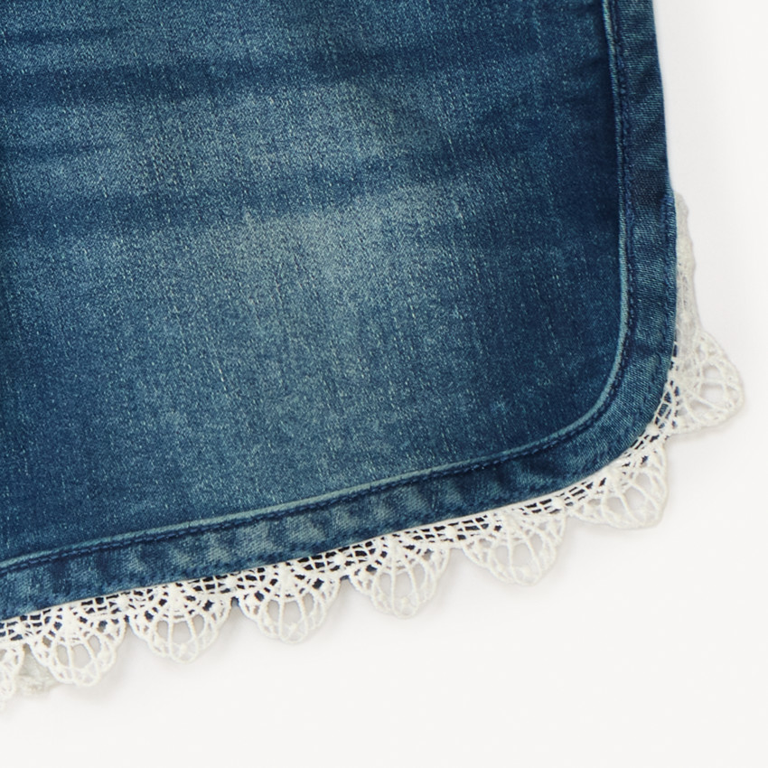 Pantalones cortos de mezclilla con cinturón atado y detalles de encaje para niña. 