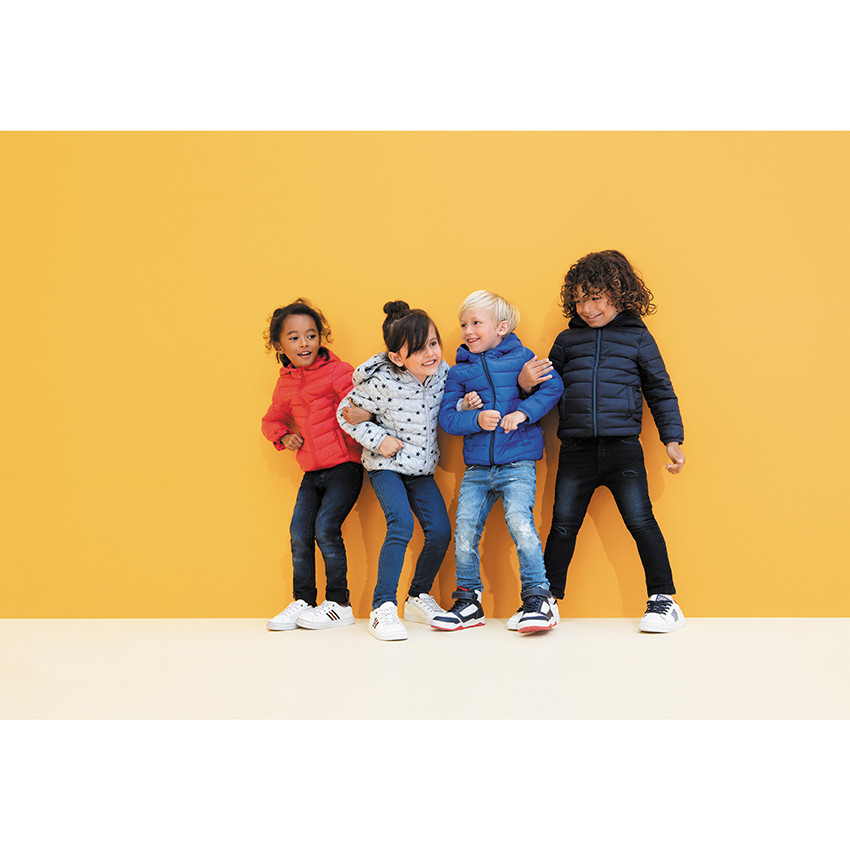 Zapatillas bajas blancas con bandas laterales para niño. 