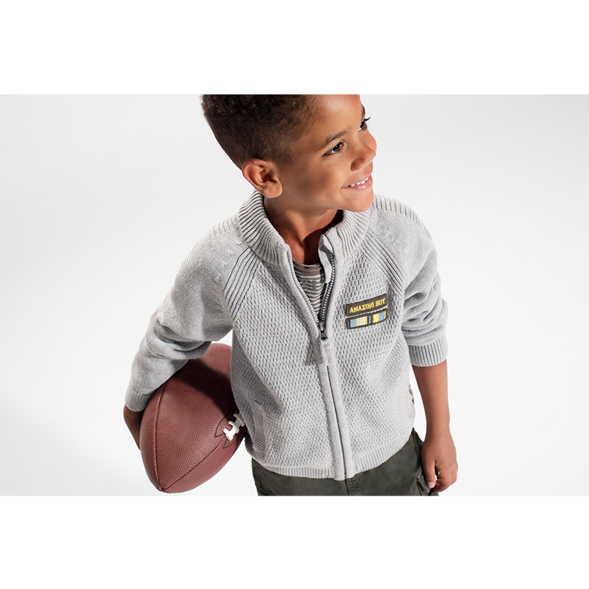 Chaqueta de punto con cremallera y parche de insignia en el pecho. 