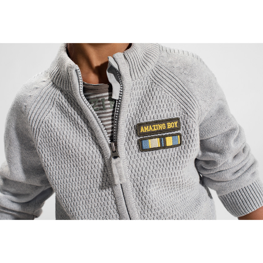 Chaqueta de punto con cremallera y parche de insignia en el pecho. 