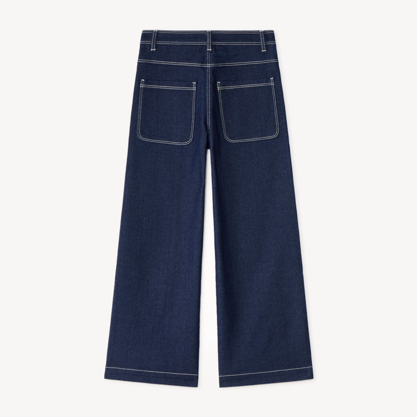 Pantalón de niña de corte amplio, liso y con bolsillos de parche. 