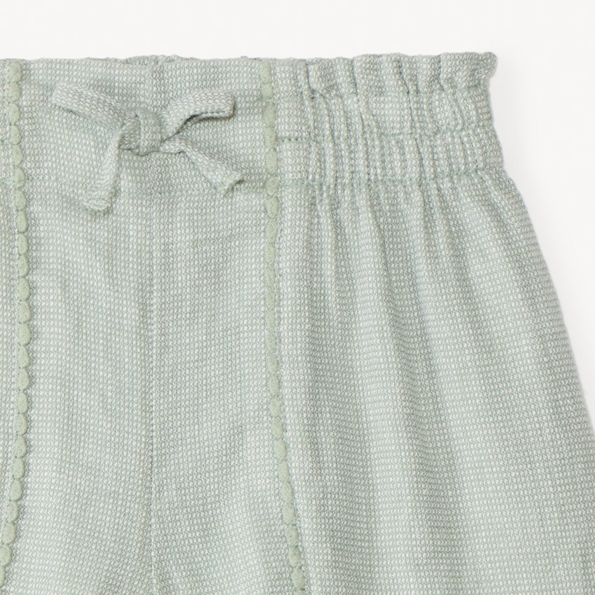 Short de tela con galón de pompones para niña 