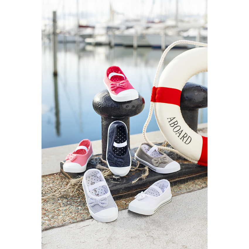 Zapatos de lona con lazo y tirante elástico para niña. 