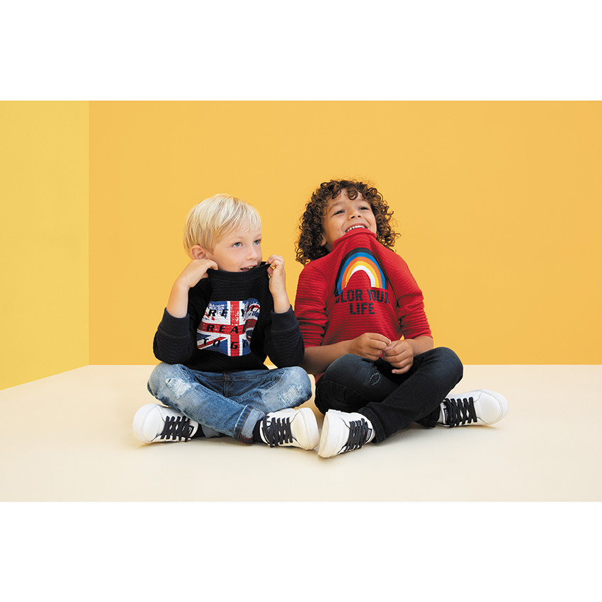 Zapatillas bajas blancas con bandas laterales para niño. 