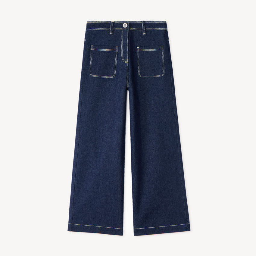 Pantalón de niña de corte amplio, liso y con bolsillos de parche. 